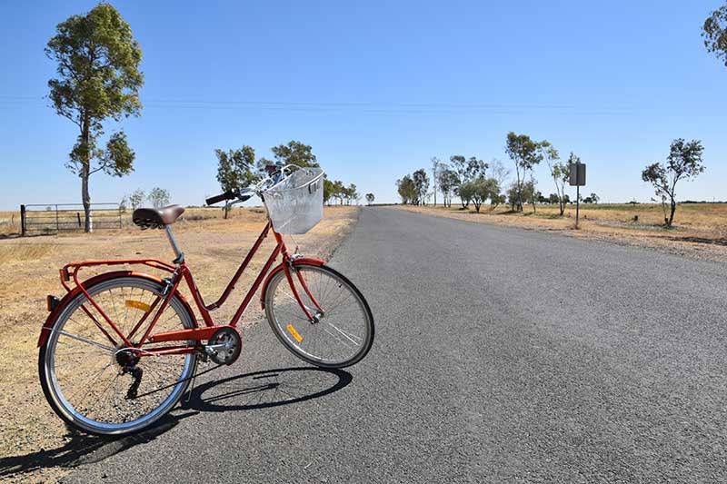 A bike on a road in the outback. Is travelling a hobby?