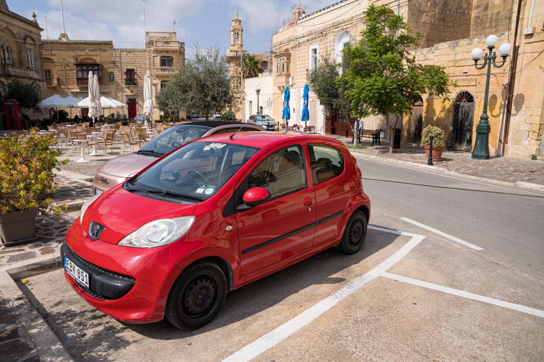 Small Red Peugeut in a car parking space