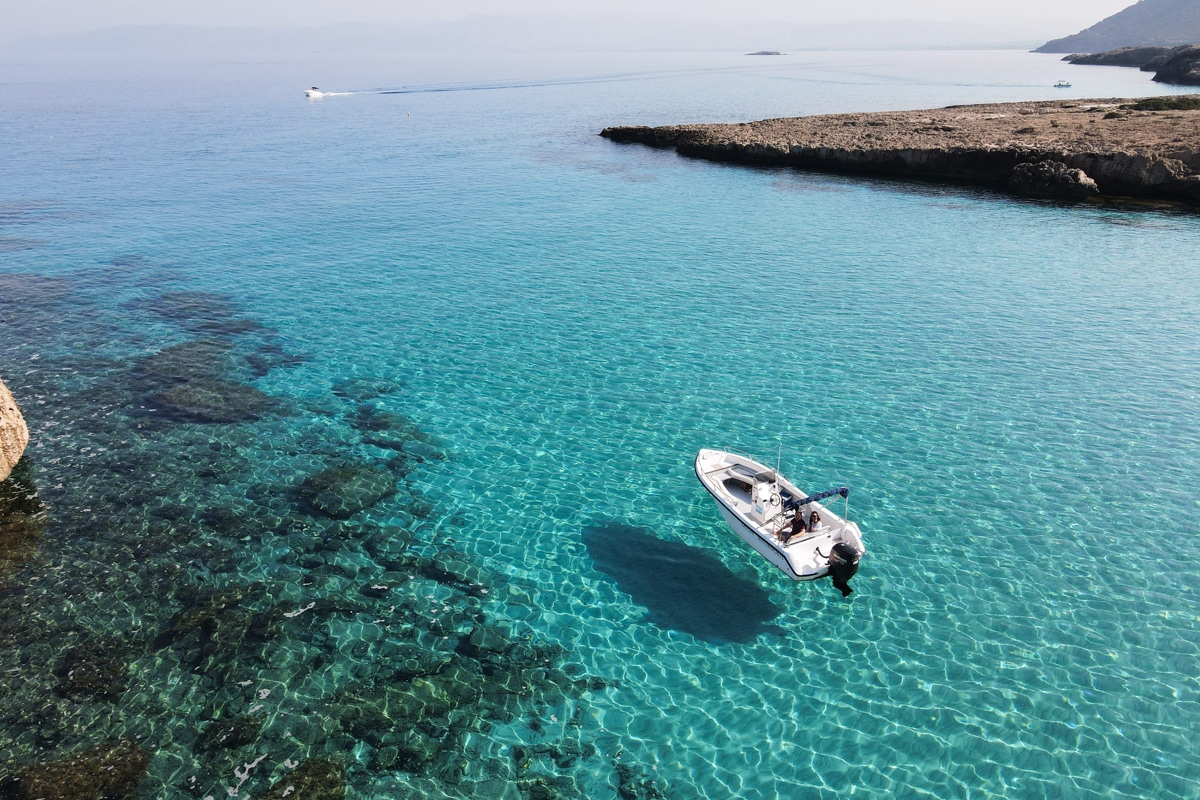 Aerial shot of white boat in clear blue wateer